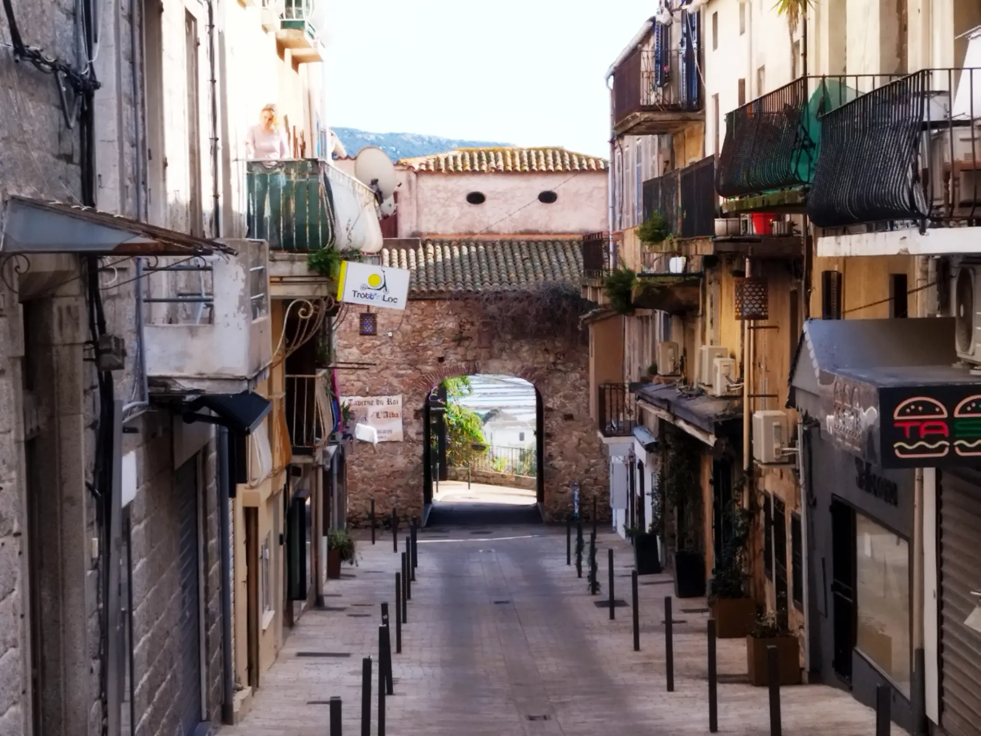 Rue de Porto-Vecchio au crépuscule avec des poubelles débordantes et des commerces fermés
